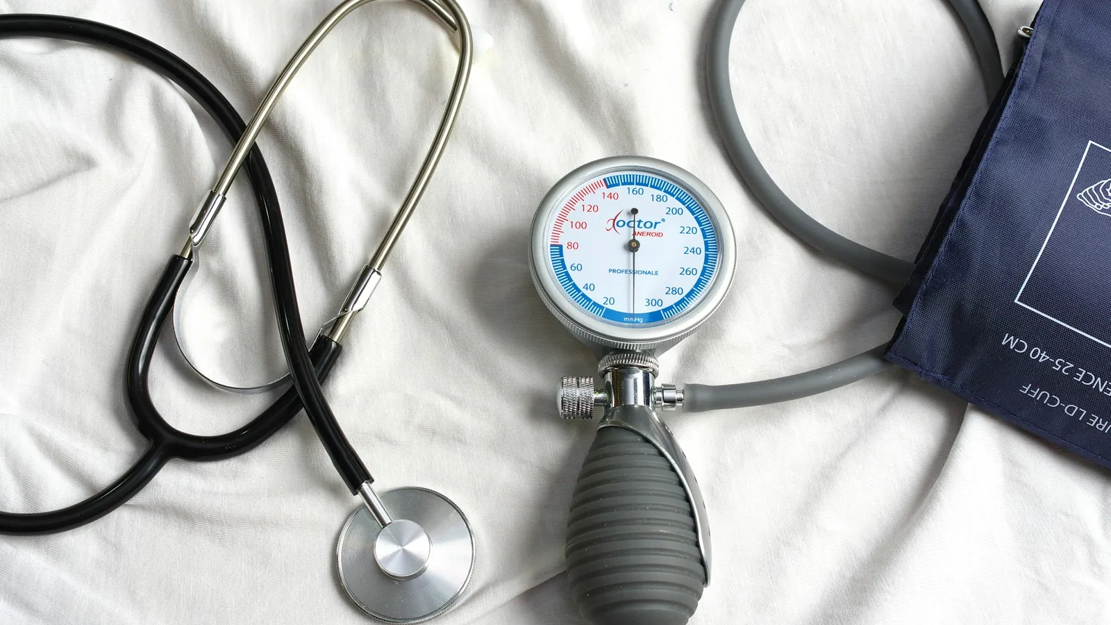 Estetoscopio y tensiómetro sobre una cama, listos para una atención médica